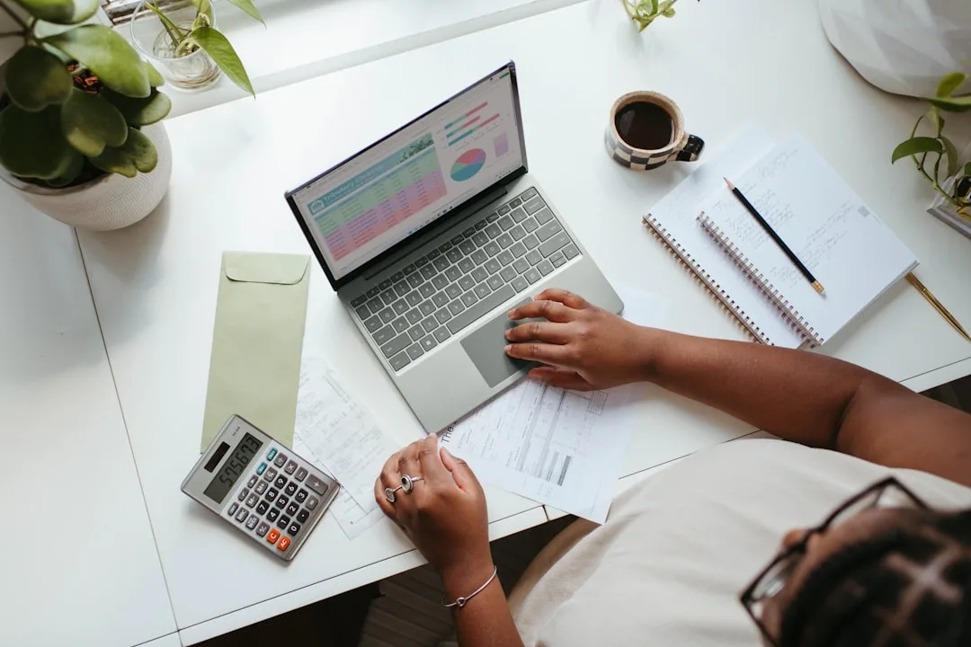 Small business owner reviewing a website budget spreadsheet on a laptop