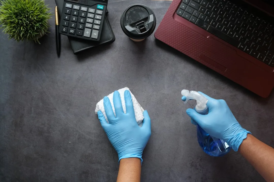 Person cleaning laptop keyboard carefully