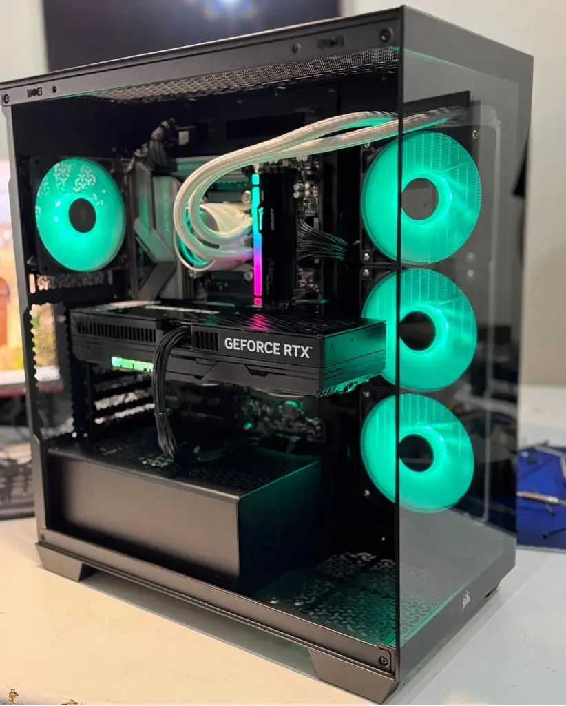 Black tempered glass gaming PC with green RGB fans and RTX 5080 graphics card